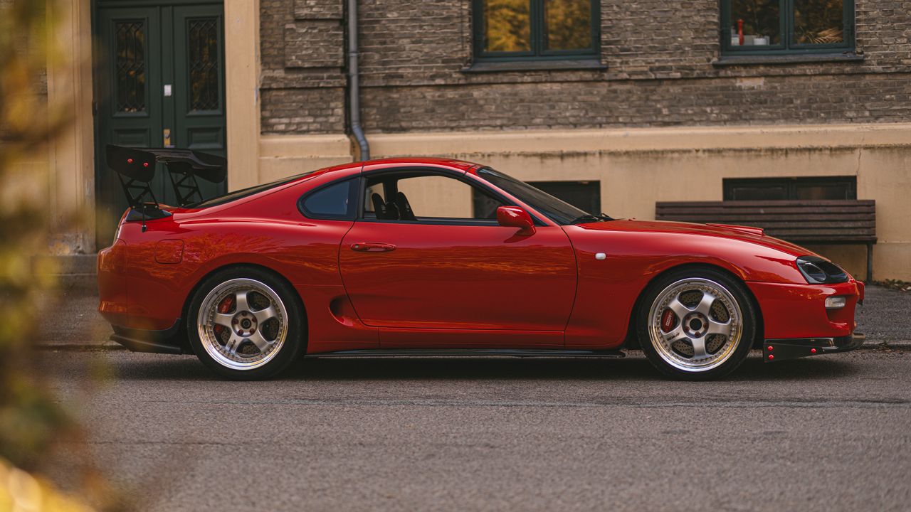 Services A stylish red sports car parked in an urban setting, showcasing sleek design.