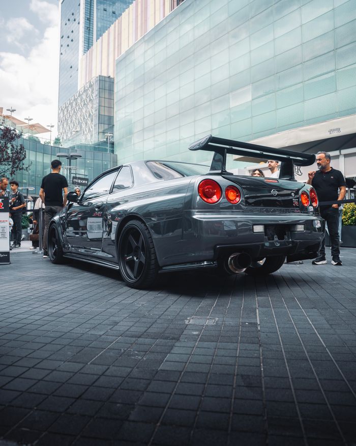 Street scene in Ankara showcasing a high-performance sports car and people interacting.